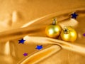 Christmas decoration on gold background, Golden balls and silk fabric. Christmas card, space for text. The decor for the new year Royalty Free Stock Photo
