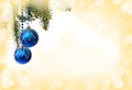 Christmas decoration. Hanging blue balls on abstract yellow golden background with space for text Royalty Free Stock Photo