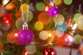 Christmas decoration. Hanging purple balls on pine branches christmas tree garland and ornaments over abstract bokeh background Royalty Free Stock Photo