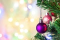 Christmas decoration. Hanging purple balls on pine branches Christmas tree garland and ornaments over abstract bokeh background Royalty Free Stock Photo