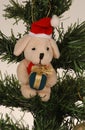 Christmas decoration Labrador puppy in Santa hat with present hanging on Christmas tree