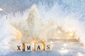 Christmas decoration on a light blue glittered background with wooden cubes forming word Christmas Royalty Free Stock Photo