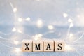 Christmas decoration on a light blue glittered background with wooden cubes forming word Christmas Royalty Free Stock Photo