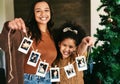 Christmas, decoration and mother and girl with Polaroid on a tree for love, happiness and celebration of holiday in a