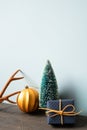 Christmas decoration ornament fir tree, golden ball, deer antler, gift box on wooden table. blue wall background Royalty Free Stock Photo