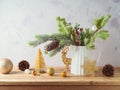 Christmas decoration with pine tree branches in vase and golden ornaments on wooden table over bright background Royalty Free Stock Photo