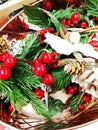 Christmas decoration of pine twigs, cones,red berries,white flower glitter, gold, red and silver flowers with sequins