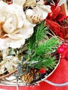 Christmas decoration of pine twigs, cones,red berries,white flower glitter, gold, red and silver flowers with sequins