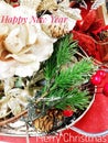 Christmas decoration of pine twigs, cones,red berries,white flower glitter, gold, red and silver flowers with sequins,card with wr
