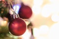 Christmas decoration. Red balls hanging on pine branches Christmas tree garland and ornaments over abstract bokeh background with Royalty Free Stock Photo