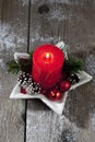 Christmas decoration, red candle, fir twig, Christmas sphere on wooden background Royalty Free Stock Photo