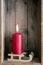 Christmas decoration red candle on a sledge in a wooden box back Royalty Free Stock Photo