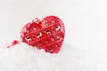 Christmas decoration - red heart with festive ornament closeup in fluffy  white snow, closeup. Royalty Free Stock Photo