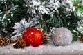 Christmas decoration red and silver balls in a tree with tinsel and pinecone in snow Royalty Free Stock Photo