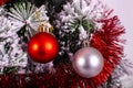 Christmas decoration red and silver balls in a tree with tinsel and pinecone in snow Royalty Free Stock Photo