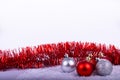 Christmas decoration red and silver balls in a tree with tinsel and pinecone in snow Royalty Free Stock Photo