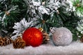 Christmas decoration red and silver balls in a tree with tinsel and pinecone in snow Royalty Free Stock Photo