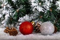 Christmas decoration red and silver balls in a tree with tinsel and pinecone in snow Royalty Free Stock Photo