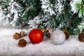 Christmas decoration red and silver balls in a tree with tinsel and pinecone in snow Royalty Free Stock Photo