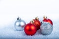 Christmas decoration red and silver balls in a tree with tinsel and pinecone in snow Royalty Free Stock Photo