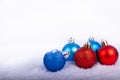 Christmas decoration red and blue ball in a tree with tinsel and pinecone in snow