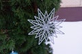 Christmas decoration silver artificial snowflake on a branch.