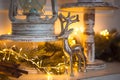 Christmas Decoration silver figure of a deer with branching horns, cinnamon sticks in festive lights garland yellow. New year, Chr