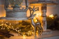 Christmas Decoration silver figure of a deer, cinnamon sticks in festive lights garland yellow.