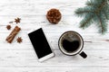 christmas decoration. smartphone, wooden table christmas tree branch, christmas cup coffee gift Royalty Free Stock Photo