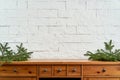 Christmas decoration with space with twigs of spruce on an shelf on the background of a brick wall