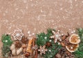 Christmas decoration with spices and cookies in the shape of snowflakes on dark brown paper background. Top view.