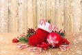 Christmas decoration with christmas stocking, pine cone, branch of spruce, candies, berry and Christmas toy on wooden table