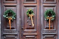 Christmas decoration - three evergreen wreaths on antique wooden door