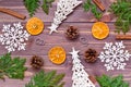 Christmas decoration with thuja branches, snowflakes, pine cones, cinnamon and mandarin on wooden background Royalty Free Stock Photo