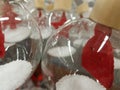 Transparent glass balls with artificial snow and red figures. Royalty Free Stock Photo