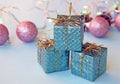 Christmas decoration for the Christmas tree in the form of small shiny gifts and balls on a blue background. Royalty Free Stock Photo