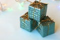 Christmas decoration for the Christmas tree in the form of small shiny gifts on a blue background Royalty Free Stock Photo