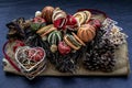 Christmas decoration. Twigs christmas tree, brown natural pine cones and variety of fruits on burlap fabric background