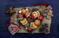 Christmas decoration. Twigs christmas tree, brown natural pine cones and variety of fruits on burlap fabric background