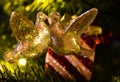 Christmas decoration of two turtle doves kissing in a tree in front of a wrapped present.