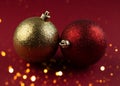 Christmas Decoration with Two Red and Gold glittering Balls on the Blurred red Background of Bright Holiday Lights. Greeting Card Royalty Free Stock Photo