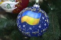 Christmas decoration, with Ukrainian national flag painted, hanging on a Christmas tree before New Year Day Royalty Free Stock Photo