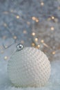 Christmas decoration. White ball nacre pearls on a snow and beautiful blurred background of glittering bokeh with glowing lights. Royalty Free Stock Photo