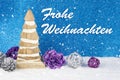 Christmas decoration with wooden pinewood figurine, baubles and pines on a background with text in German `Frohe Weihnachten ` Royalty Free Stock Photo