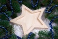 Christmas decoration with wooden star snow and fir branches.