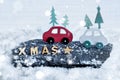Christmas decoration of wooden XMAS letters and wooden cars in a snow scene