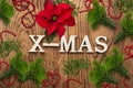 Christmas decoration and the word `x-mas` on wooden background