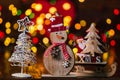 Christmas decorations against blurred background and out of focus lights. Decorative wooden snowman and glittery Christmas balls Royalty Free Stock Photo