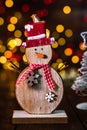 Christmas decorations against blurred background and out of focus lights. Decorative wooden snowman and glittery Christmas balls Royalty Free Stock Photo