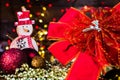 Christmas decorations against blurred background and out of focus lights. Decorative wooden snowman and glittery Christmas balls Royalty Free Stock Photo